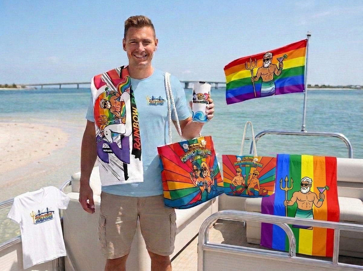 The full 2026 Rehoboth Bay Pride collection on the bay — the bridge and waves tee, v-neck tee, Rainbow Raft Up and Daddy Neptune towels, the 2026 tumbler, the Neptune flag, and the mermaid and mermen weekender bags.
